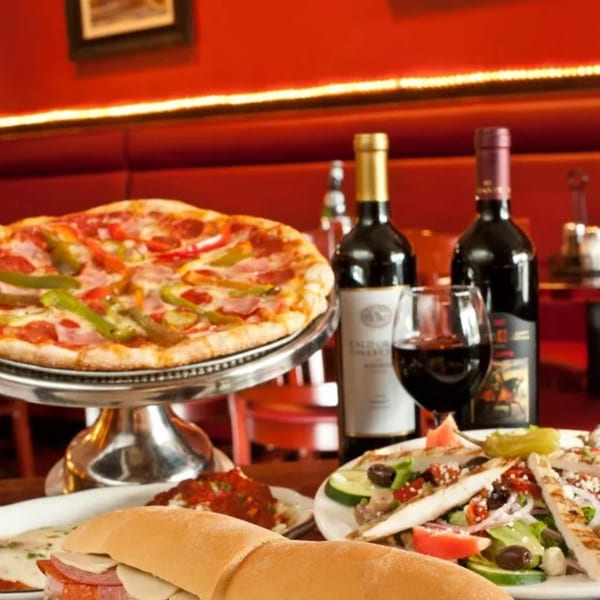 Mercato's Italian Grill: a table laden with pizza, a sub sandwich, salad, and red wine.