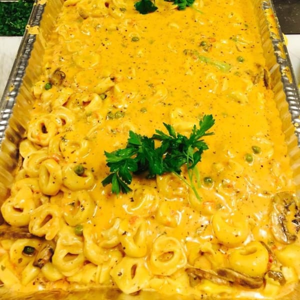 Mercato's Italian Grill's tortellini pasta in a creamy orange sauce with peas, mushrooms, and parsley.