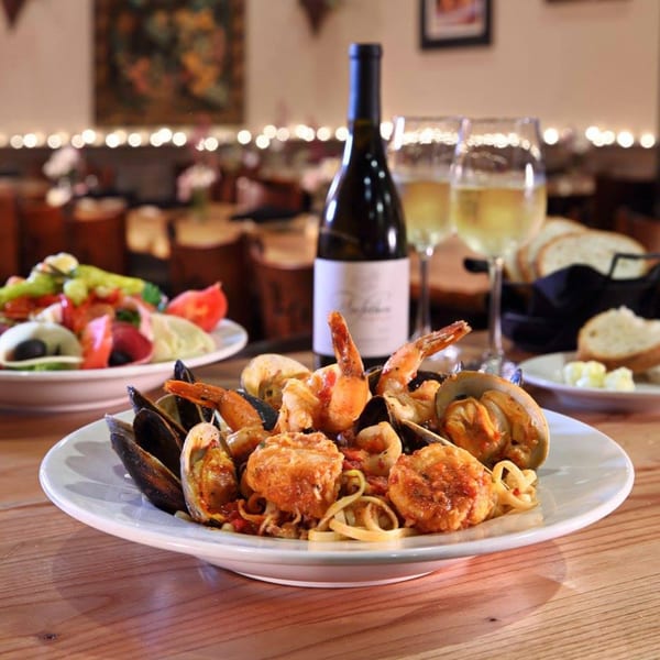 Mercato's Italian grill and Restaurant seafood pasta with mussels, shrimp, and scallops, wine, and salad.