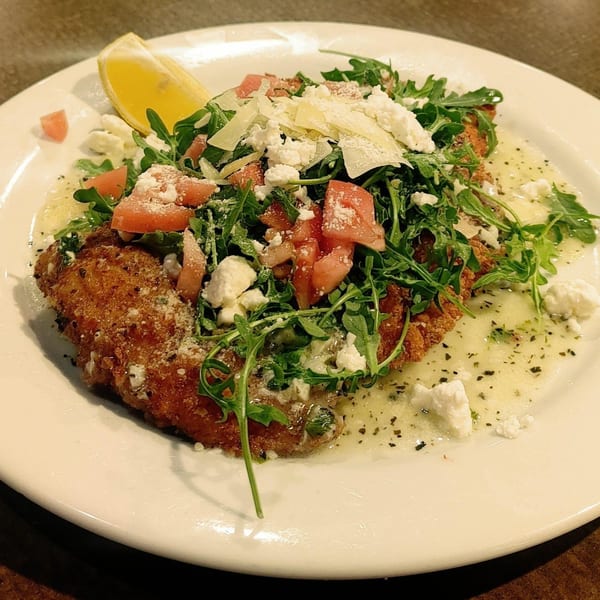 Mercato's Italian Grill's breaded chicken cutlet topped with arugula, tomatoes, feta, and parmesan.