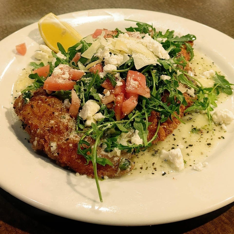 Mercato's Italian Grill's breaded chicken cutlet topped with arugula, tomatoes, feta, and parmesan.